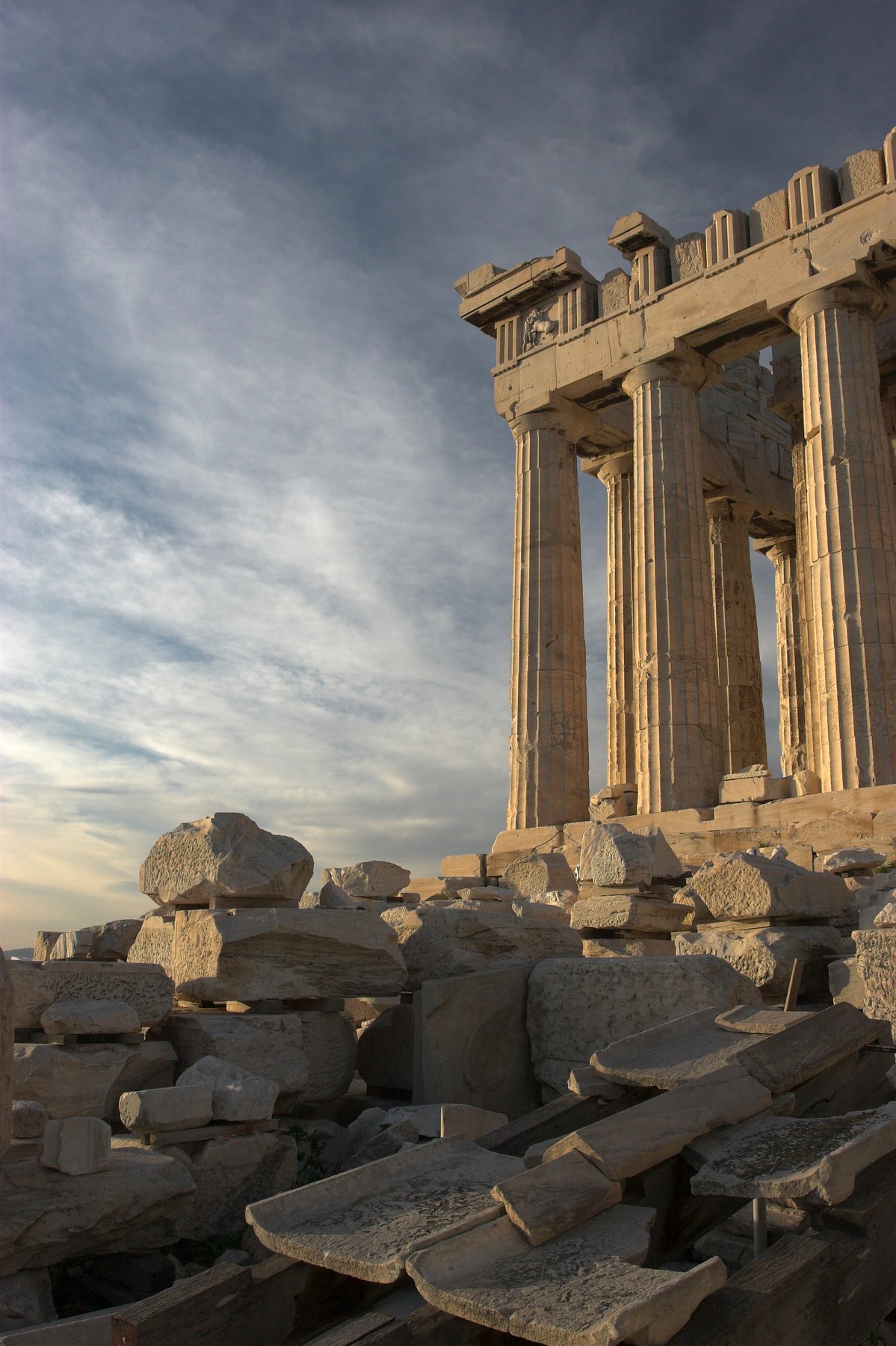 The Parthenon seen from the south, its colonnade of Doric columns standing on the Acropolis rock with a clear sky behind, partial restoration scaffolding removed.