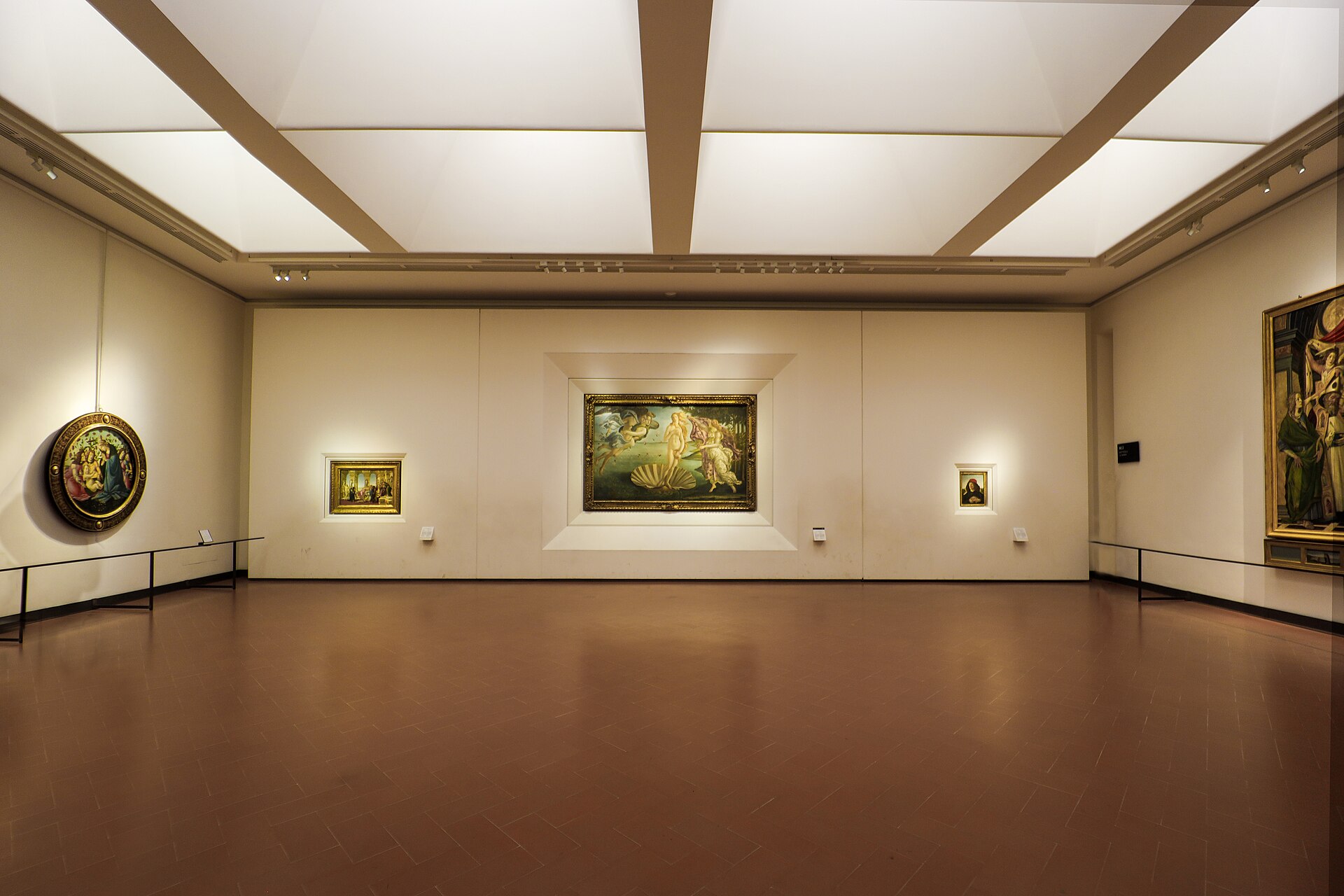 The Botticelli room of the Galleria degli Uffizi, Sala 12, with The Birth of Venus visible on the long wall and visitors gathered in front of it.