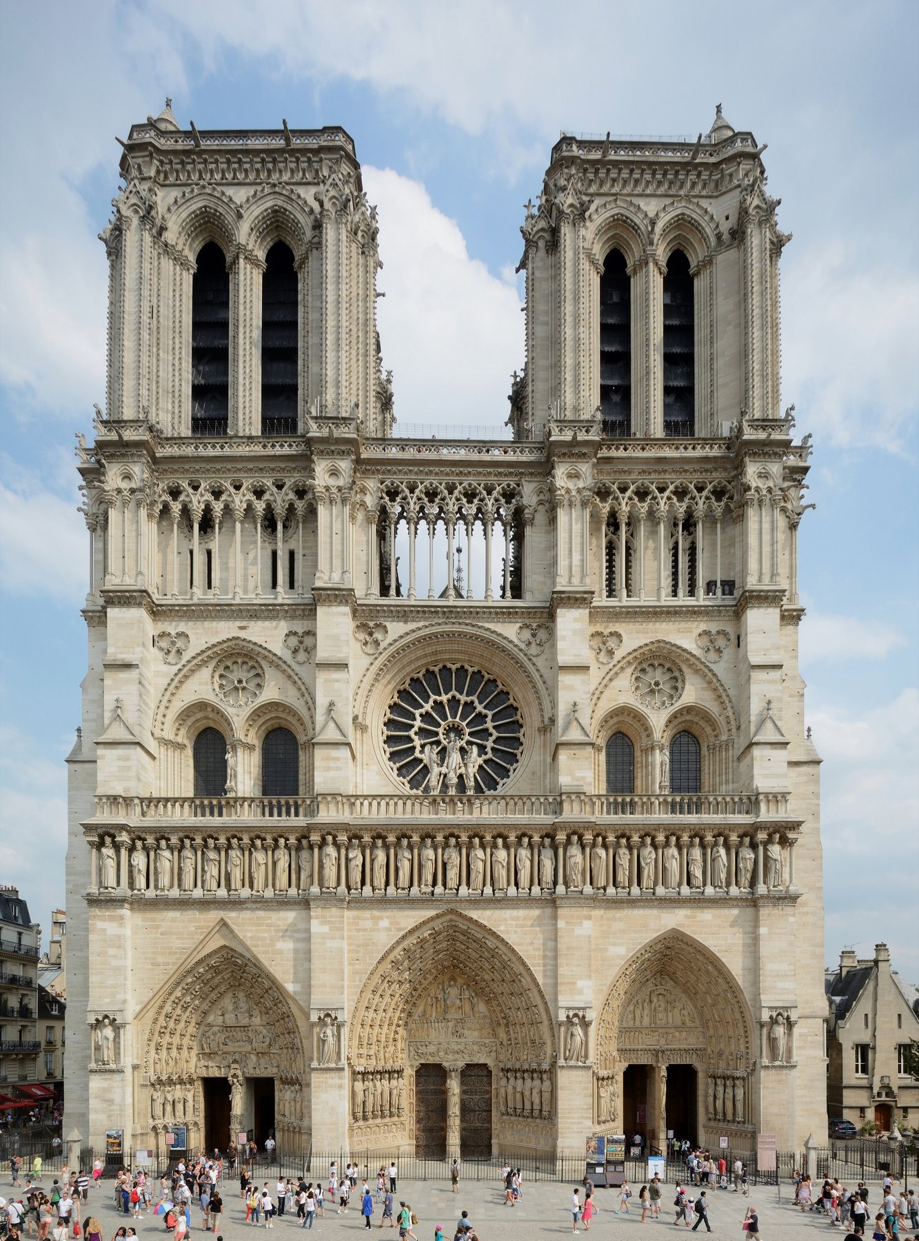 The west facade of Notre-Dame de Paris with its twin towers, central rose window, and the three sculpted portals, photographed before the 2019 fire.