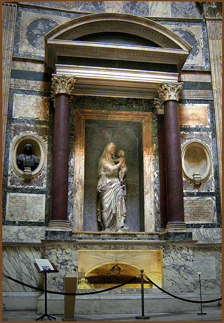The tomb of Raphael inside the Pantheon: a plain sarcophagus beneath a niche holding Lorenzetto's Madonna del Sasso, with Pietro Bembo's Latin epitaph cut into the wall.