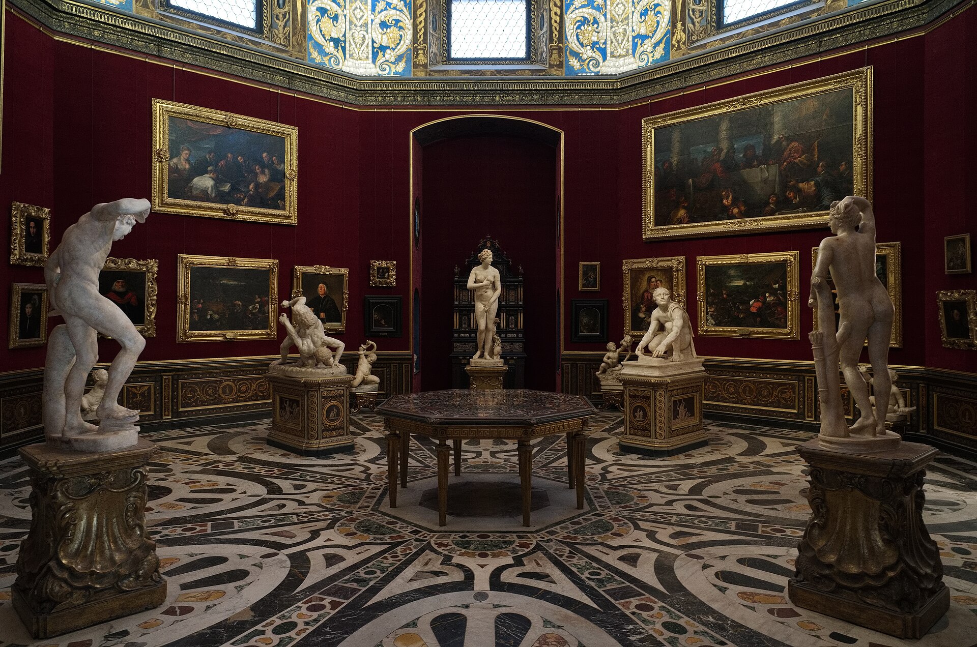 The Tribuna of the Uffizi, the octagonal red-walled domed room at the center of the East Wing, designed in 1581 to house the most precious objects in the Medici collection, with eighteenth-century paintings, sculptures, and gemstones still arranged in the original cabinet-of-curiosities style.